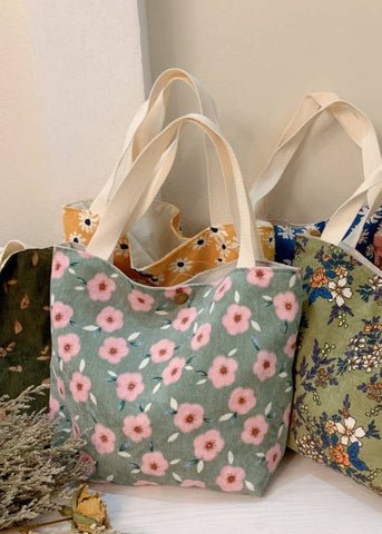 corduroy multi use bag with several different floral patterns in yellow, sage, green, blue and rose